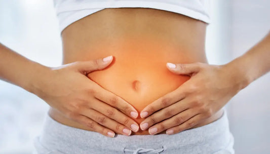 Woman holding stomach area to illustrate gut health and digestive wellness