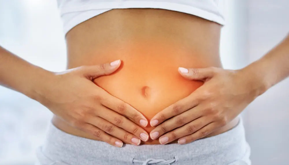 Woman holding stomach area to illustrate gut health and digestive wellness