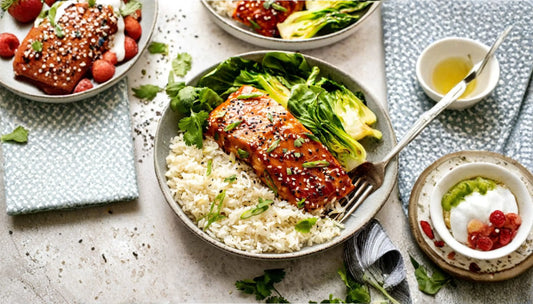 baked miso salmon fillet with sesame seeds and cilantro over white rice with bok choy in a gray bowl