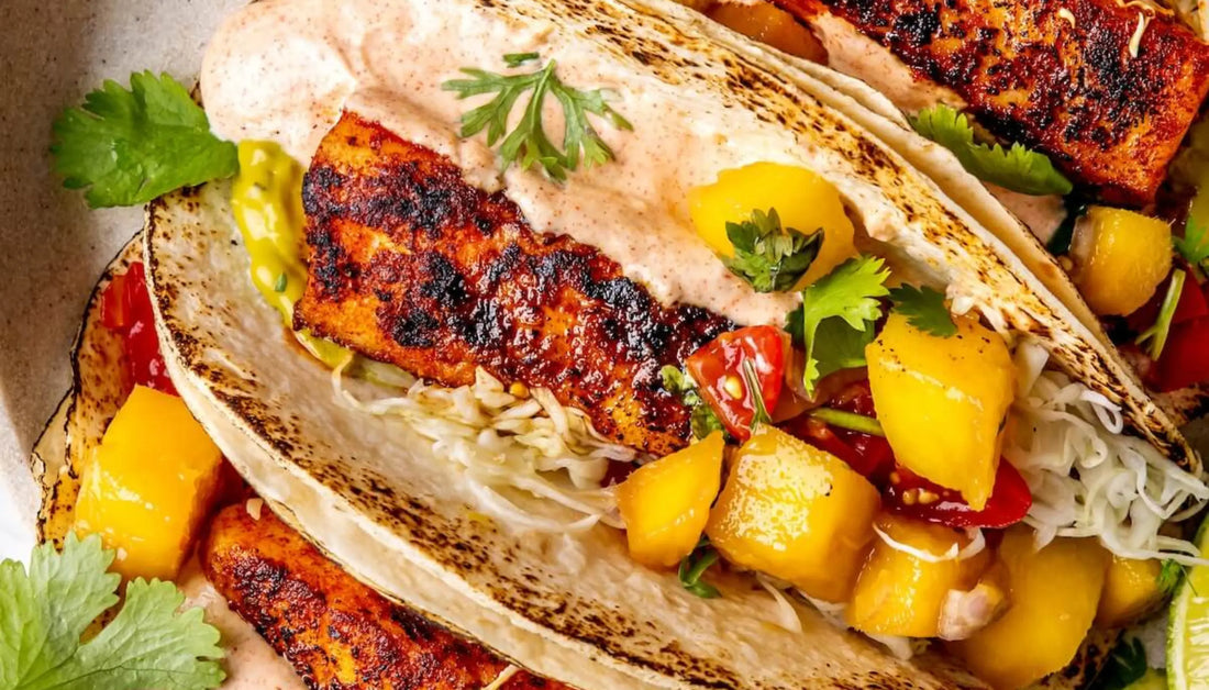 blackened fish tacos with mango salsa, shredded cabbage, chipotle crema, and cilantro in charred flour tortillas