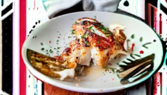 Sea bass health benefits on display with a seared, seasoned fillet flaked open and garnished with herbs in a rustic ceramic dish