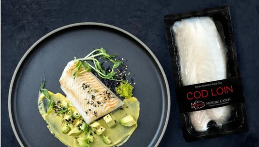 Cod fish fillet served with avocado and garnish beside Nordic Catch packaged cod loin on a dark background.