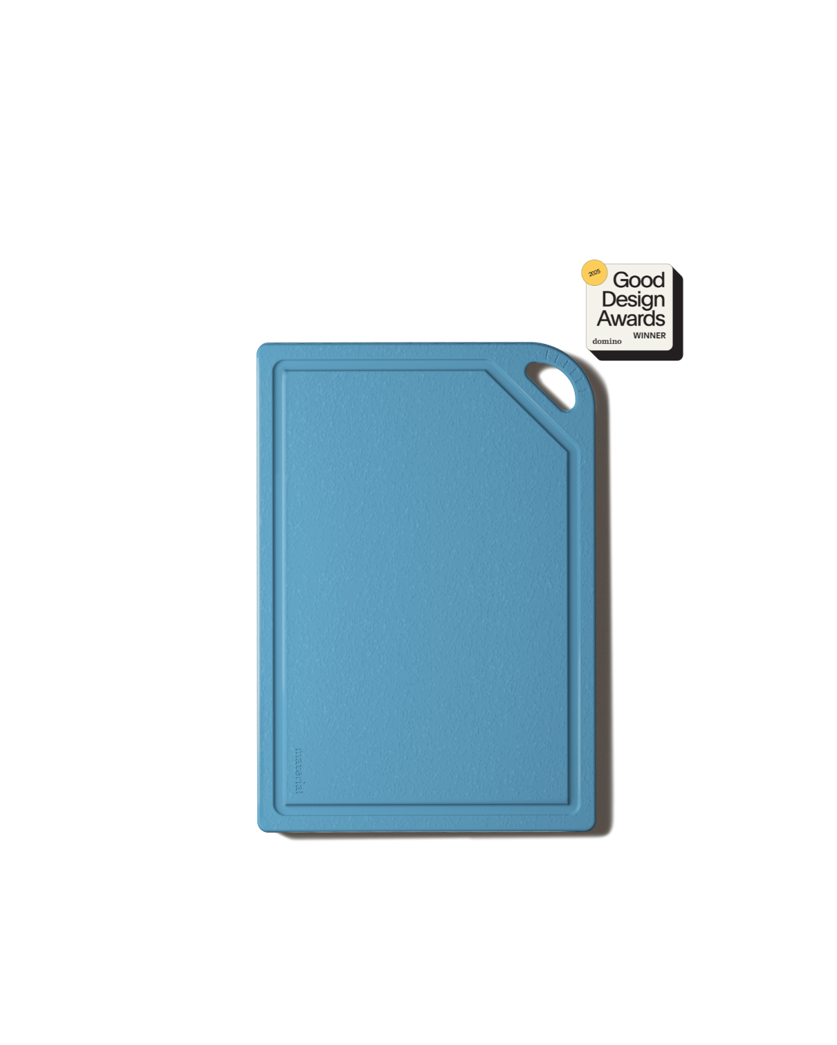 Blue cutting board with juice groove and black handle displaying Good Design Awards winner certification badge on black background