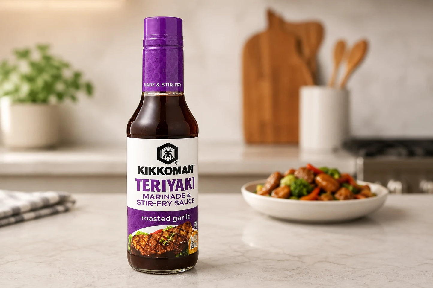 Kikkoman Teriyaki sauce bottle on a kitchen counter with a dish of stir-fry in the background.