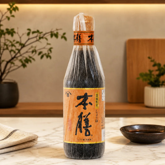 Bottle of Japanese soy sauce on a wooden surface with a plant and wooden board in the background