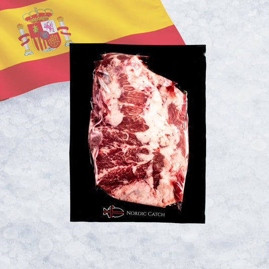 A vacuum-sealed raw cut of marbled Iberico presa steak, with a Spanish flag in the upper left and a light icy background. The card shows the brand name Nordic Catch.