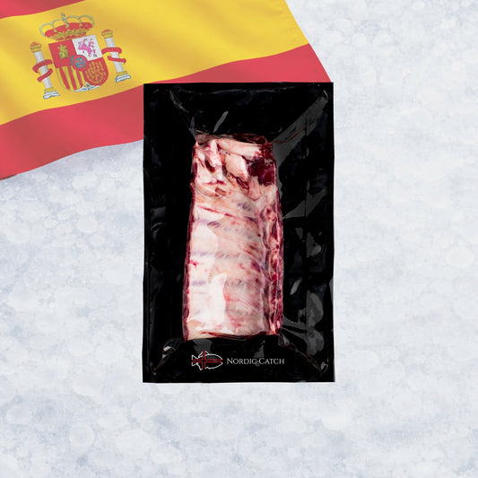 A vacuum-sealed pack of raw Iberico ribs, shown on a light icy background with a Spanish flag in the upper left corner. The package has the brand name 'NORDIC CATCH' printed near the bottom.