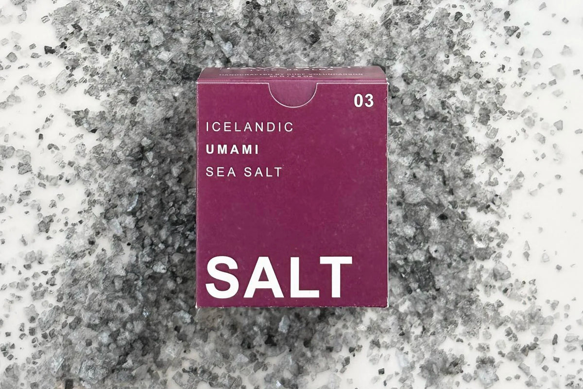 A purple box of Icelandic sea salt sitting on a bed of grey salt flakes