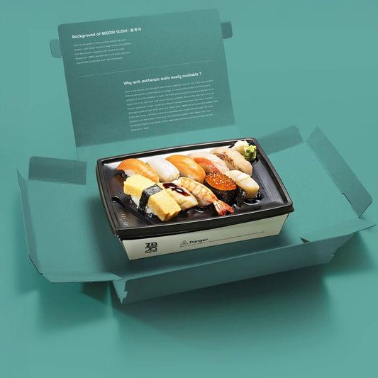 Omakase kit featuring assorted sushi pieces in premium packaging with informational text inside the box lid.